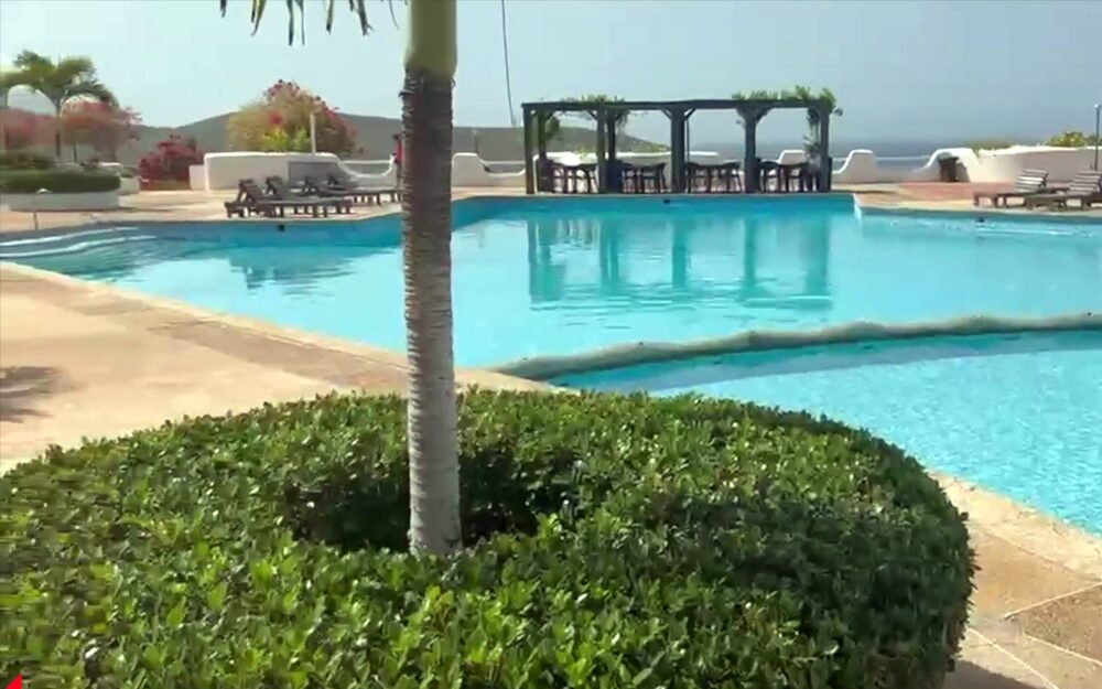 Piscina de Colinas de La Caranta, con el mar detrás