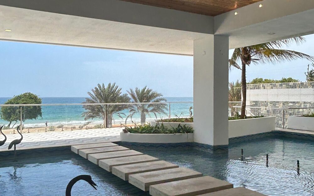 Piscina de Las Olas Condominium, con la playa privada y el mar detrás