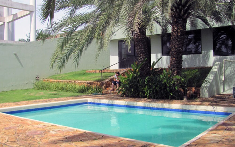 Piscina y jardín de palmeras de la casa de Playas del Ángel