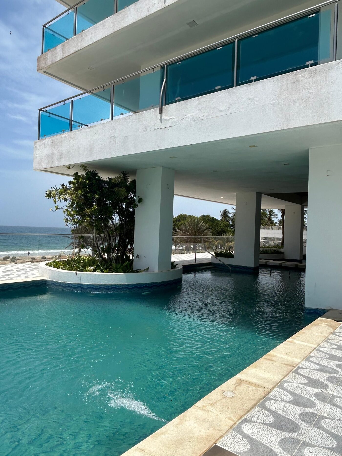 Piscina del edificio, con la playa al fondo