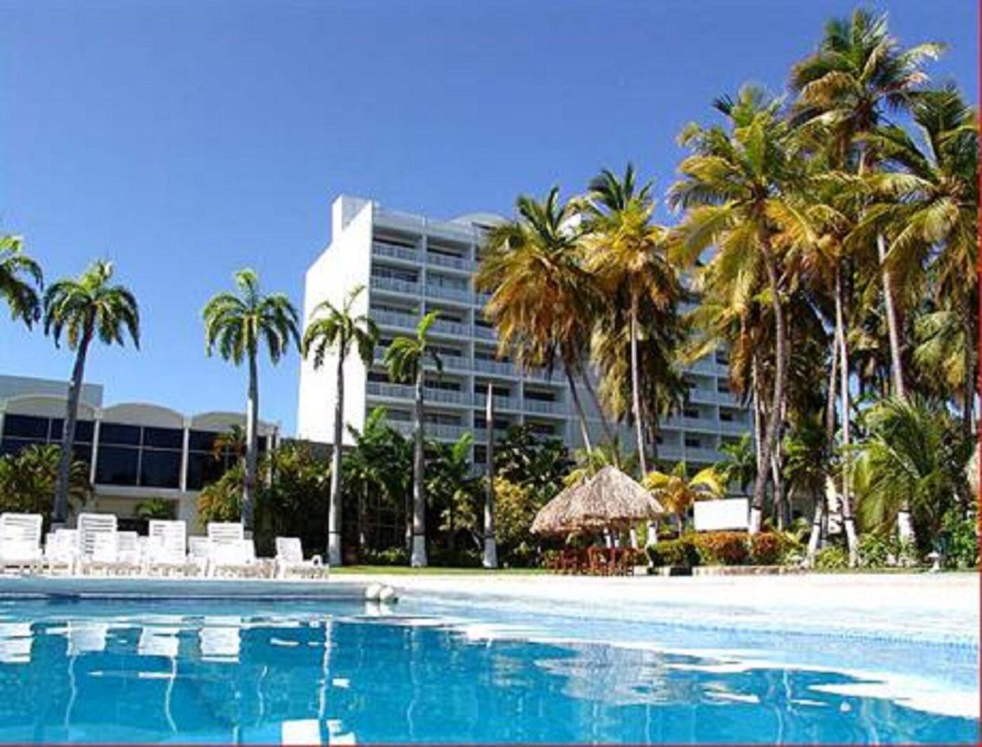 Las dos torres del Hotel Bella Vista vistas desde la piscina, entre palmeras