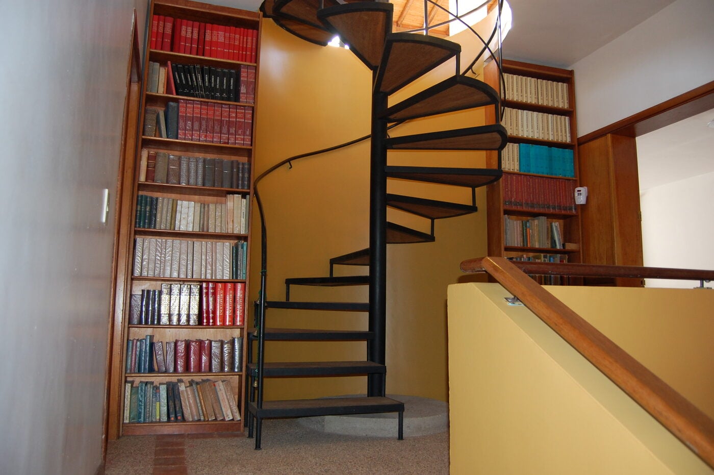 Escalera de caracol junto a la biblioteca de pared completa