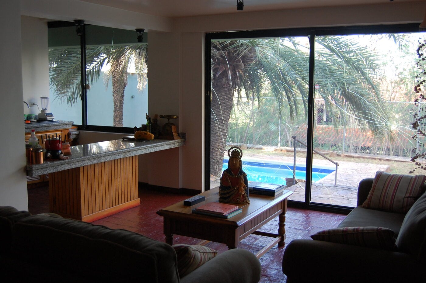 Salón con ventanal corredizo y la piscina al fondo