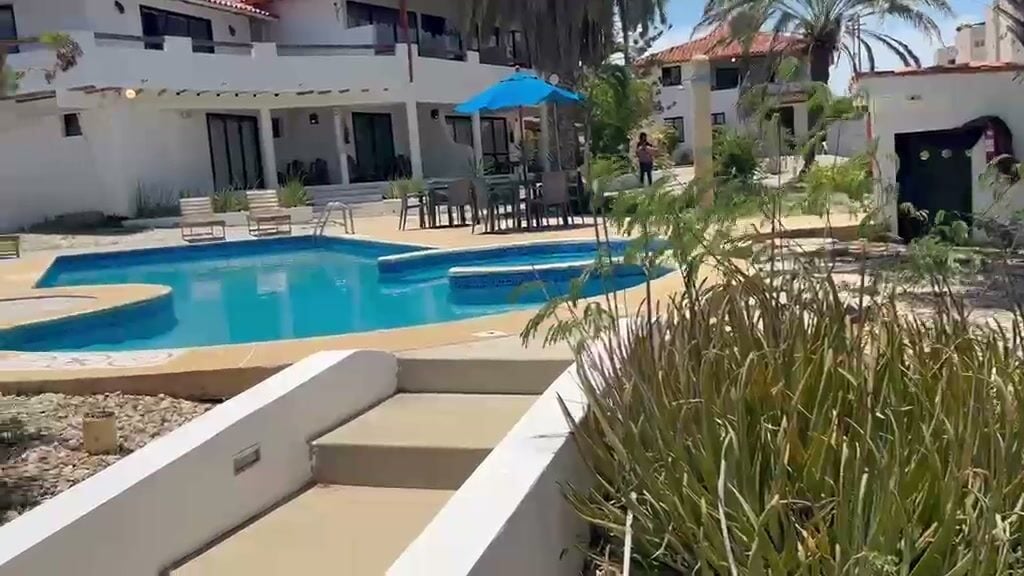 La piscina de la posada con el módulo de habitaciones al fondo