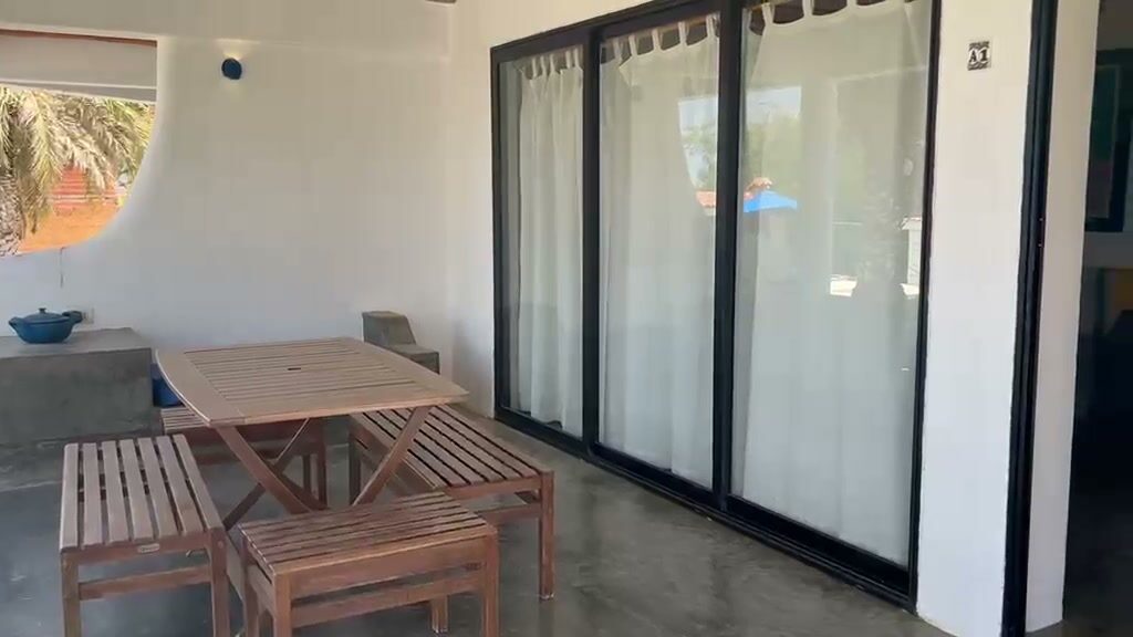 Terraza de una de las unidades, con mesa y ventanales