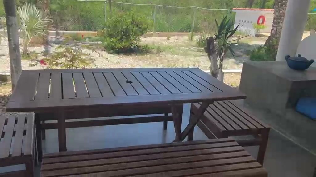 Mesa larga de madera junto al mesón de la parrillera