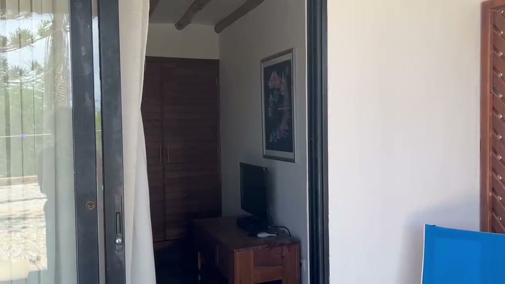 Interior de una habitación, con televisor y armario