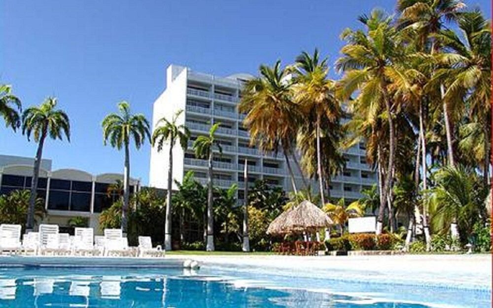 Las dos torres del Hotel Bella Vista vistas desde la piscina, entre palmeras