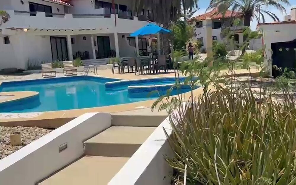 Piscina de la posada de El Yaque, con el módulo de habitaciones al fondo