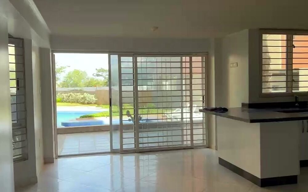 Salón a estrenar del apartamento de Punto Real, con el ventanal abierto a la piscina