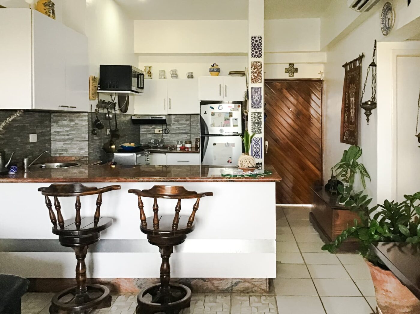 La cocina equipada, con su barra y sus taburetes