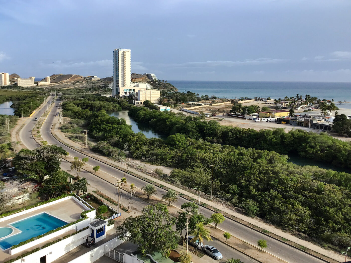 Vista desde el apartamento hacia el mar, con la avenida y el manglar en primer plano