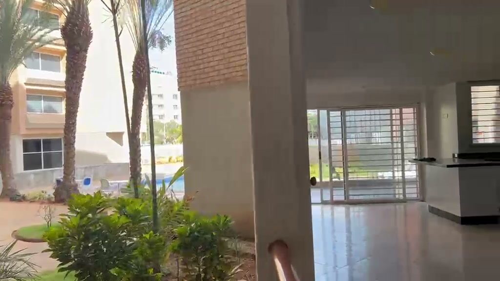 La llegada al apartamento por el jardín, con la piscina al lado