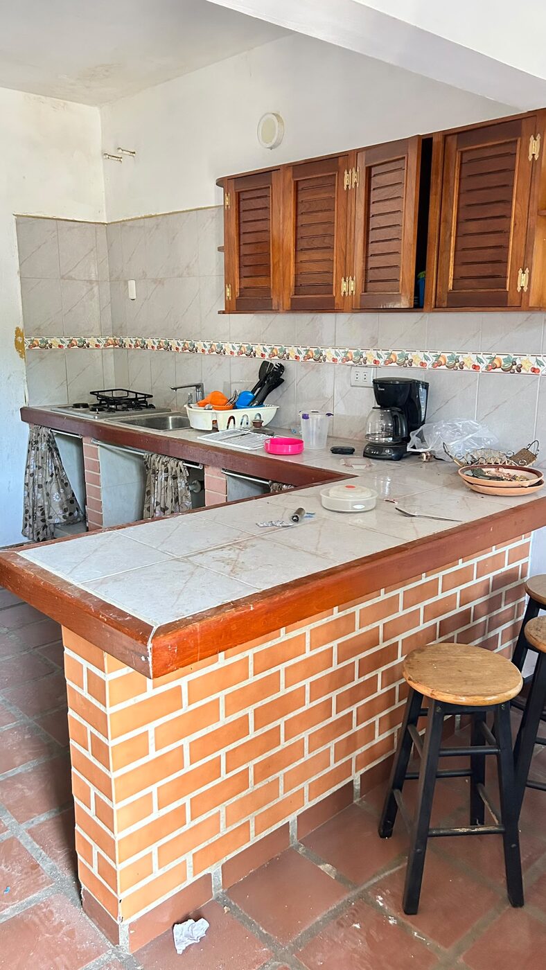Una de las cocinas, con barra de ladrillo y taburetes