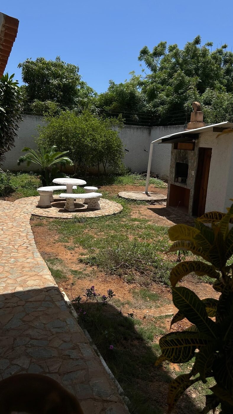 El jardín, con la mesa de piedra y la parrillera