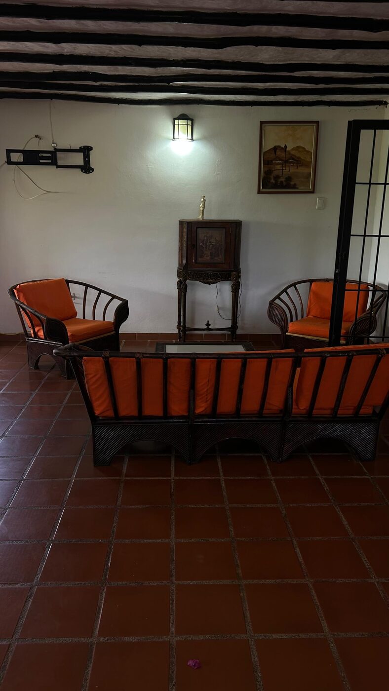 La sala de la planta alta, con los muebles de mimbre y el techo de vigas