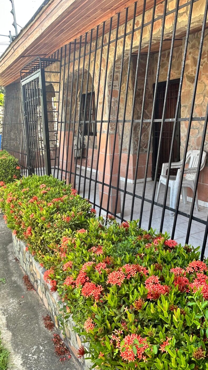 El frente de la casa, con sus rejas y el jardín de flores