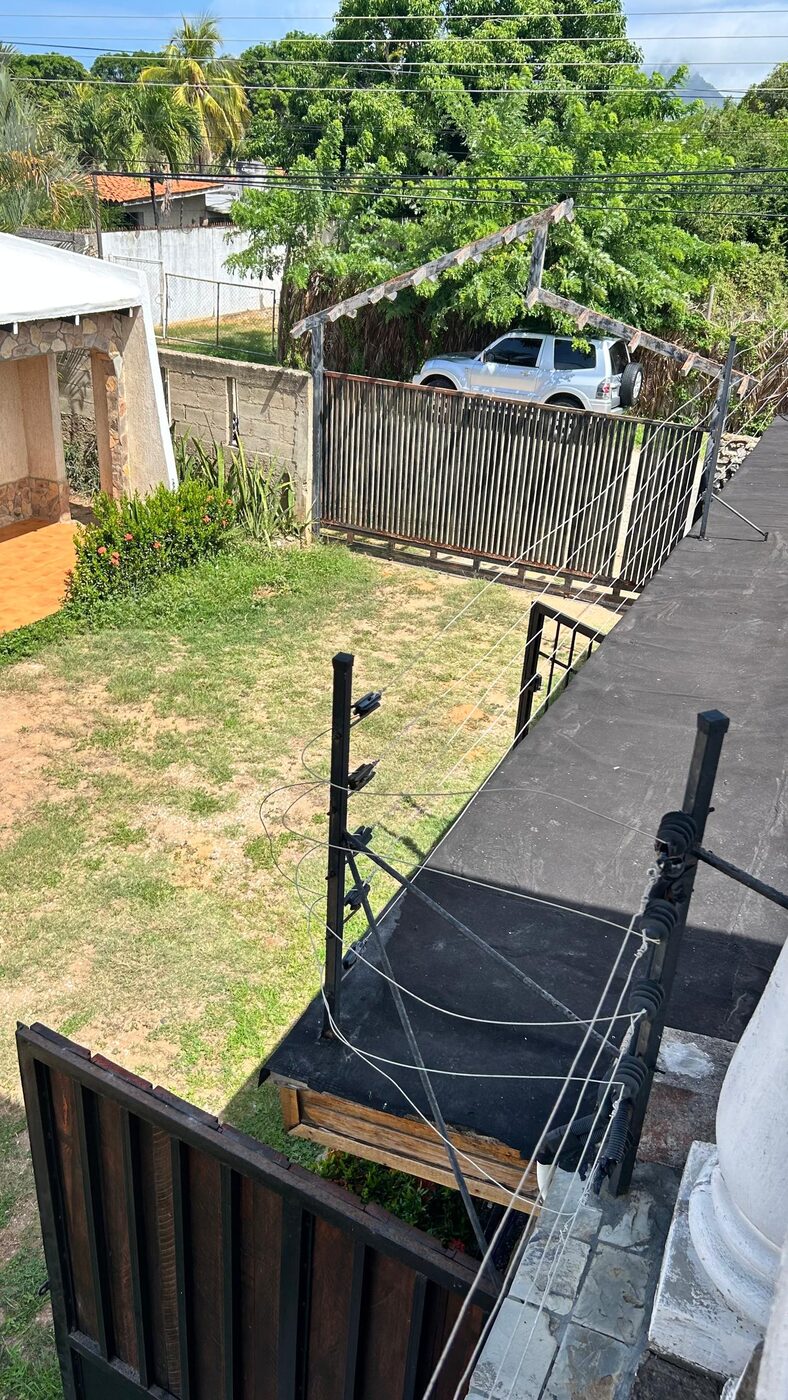 El terreno cerrado visto desde la terraza, con la cerca y el portón